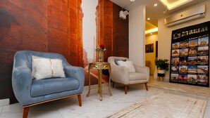 A living room with two sofas, a small table with a vase, and a wall with a poster.