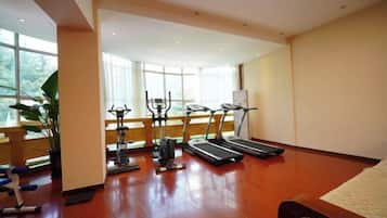 Een sportschool met loopbanden, hometrainers en krachtapparaten.