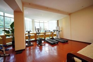 A gym with treadmills, stationary bikes, and weight machines. - Westqiang Homeland Hotel (Mao County)