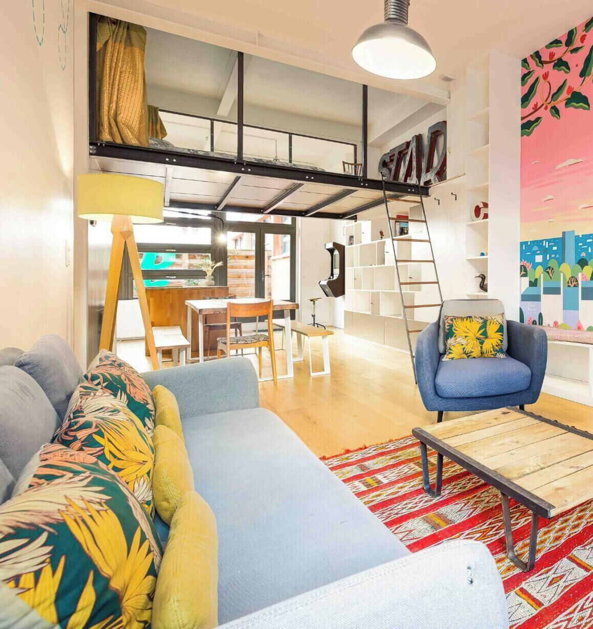 A modern living room with a sofa, armchair, and a dining area with a table and chairs.