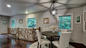 A dining area with a round table, chairs, and a rustic wooden bench. - Creekside, spacious home for 8; 9 mi. Highlands, close Sky Valley, GA (Scaly Mountain)