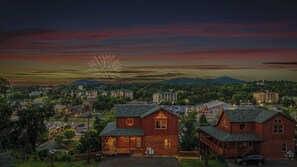 Un hôtel de style chalet en bois, doté d’une véranda et offrant une vue sur les montagnes.