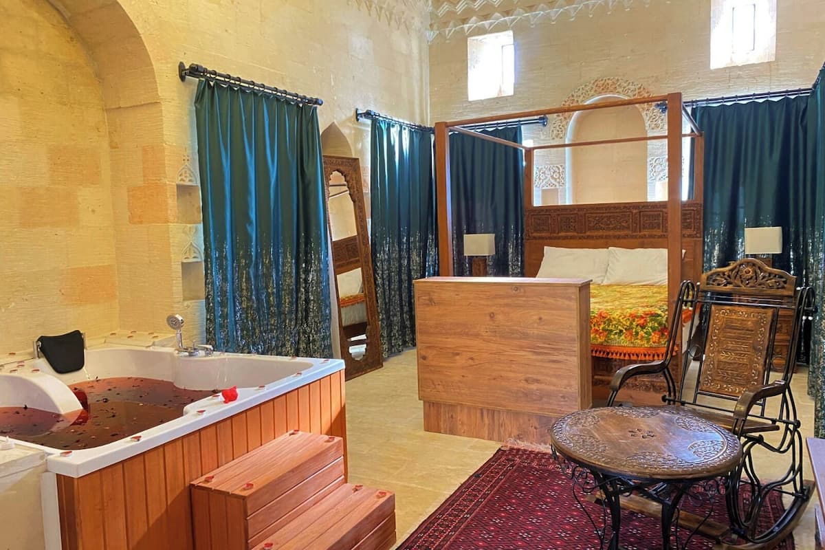 Ein traditionell eingerichtetes Zimmer mit einem hölzernen Bett, einer großen Badewanne und einem kleinen Tisch.