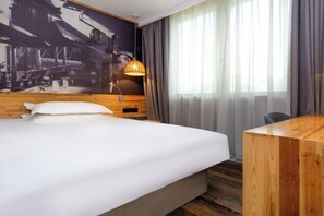 A hotel room with a large bed, a wooden desk, a wall-mounted lamp, and a window with curtains. - Tuke China Hotel (Taizhou Luqiao Shili Branch) (Taizhou)