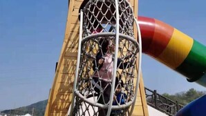 A playground structure with a netted climbing area and a slide. - Junting Hotel, Taohua Island (Zhoushan)