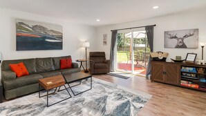 Ein modernes Wohnzimmer mit einer Couch, einem Couchtisch und einem Landschaftsbild.