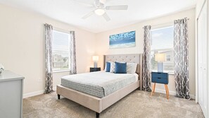 A bedroom with a bed, nightstands, a ceiling fan, and a window with curtains. - Exclusive Champions Gate Retreat w/ Private Pool (Davenport)