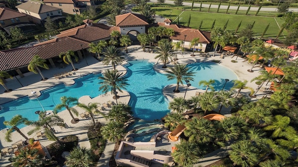 An aerial view of a resort with multiple swimming pools, palm trees, and resort buildings.