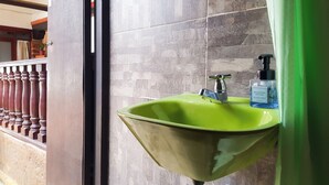 A bathroom with a green sink, a modern faucet, and a bottle of hand soap. - Casa de la Villa (Villa de Leyva)