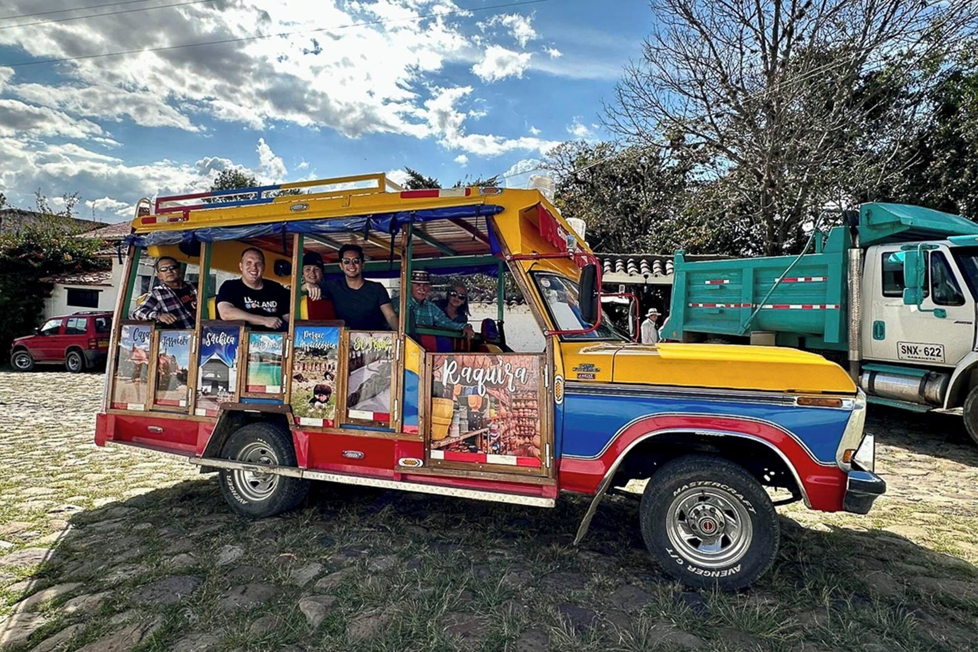 Un camión de comida colorido con diseño vintage, estacionado sobre adoquines.