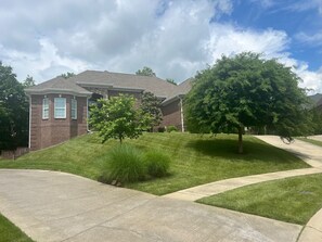 Stroll up the paved driveway to this charming two-story home, surrounded by a lush lawn and mature trees.