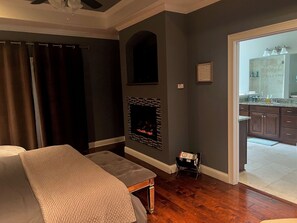 Relax in a cozy room with a comfortable bed, fireplace, and large window.