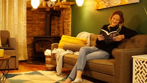 Ein gemütliches Wohnzimmer mit einer Couch, einem Kamin und einer Leselampe.