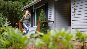 Ein Haus mit der Hausnummer 521, einer Holzterrasse und einem kleinen Baum davor.