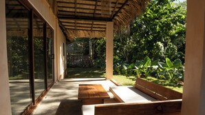 An outdoor seating area with wooden benches and a thatched roof. - El Pueblito  (Samaná)
