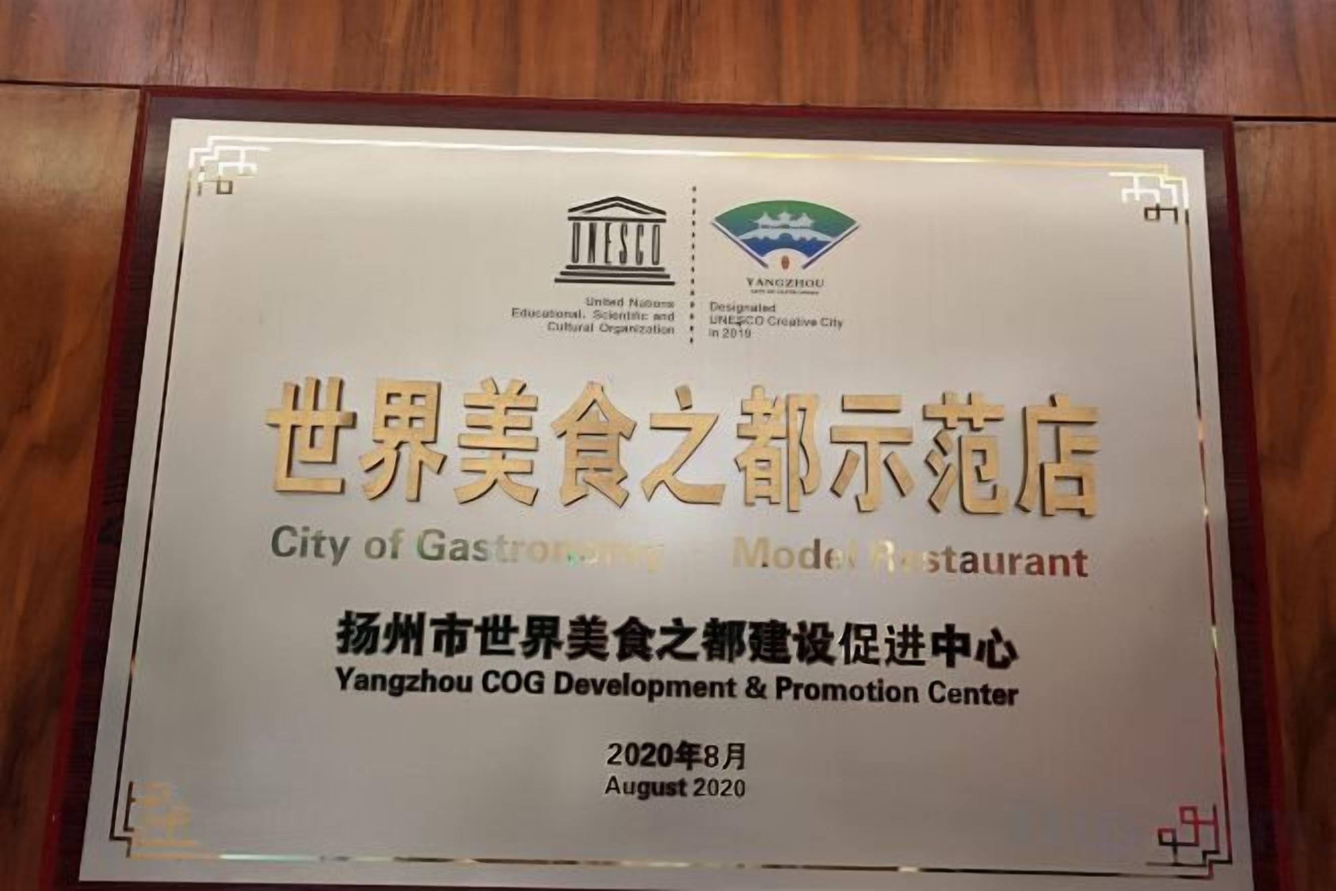A framed certificate or award plaque with text and logos, likely related to a restaurant or culinary achievement.