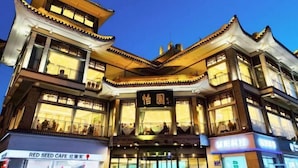 A traditional building with multiple floors, large windows, and a sign in the center. - Yiyuan Hotel (Yangzhou)