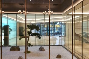 A modern interior with glass partitions, a bonsai tree, and a minimalist design. - Yiyuan Hotel (Yangzhou)