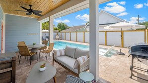 An outdoor patio area with a pool, a ceiling fan, wicker furniture, and a barbecue grill. - Designer House-Pool-Walk 2 beach (Panama City Beach)