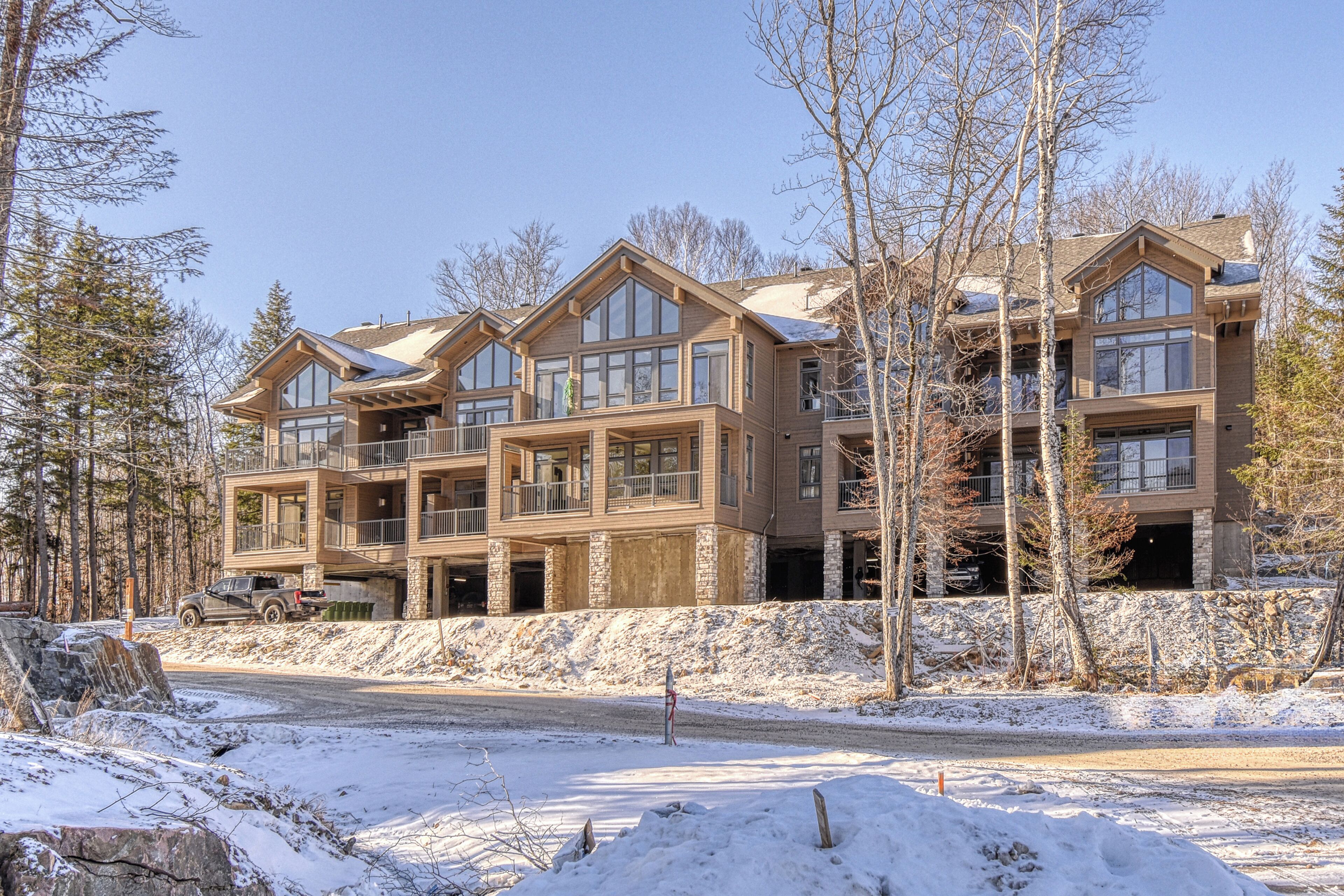 A multi-story lodge with a stone facade, large windows, and a balcony.