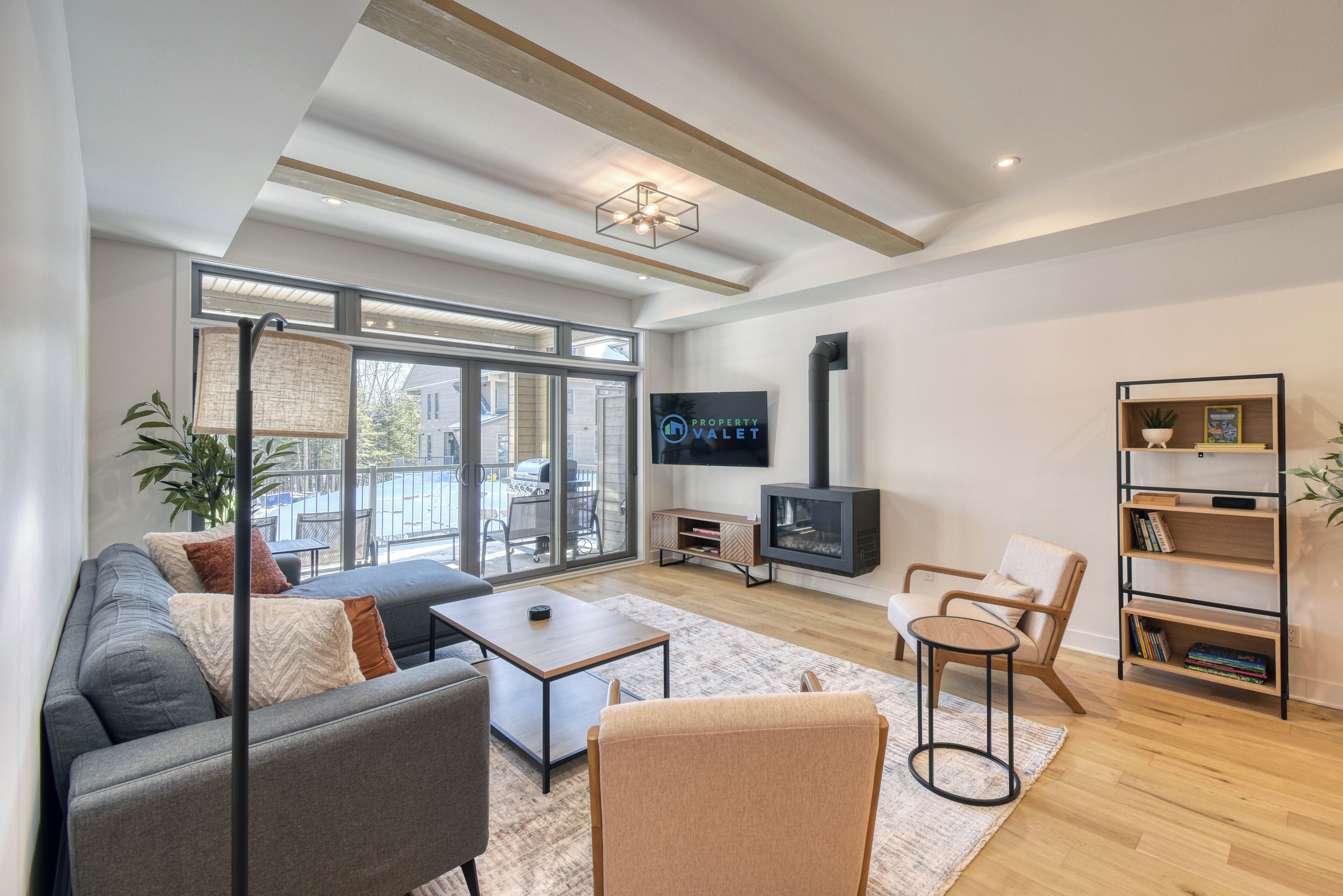 A modern living room with a sofa, coffee table, armchair, and TV.