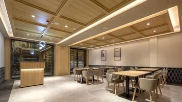 A modern interior with a reception desk, seating area, and a staircase.