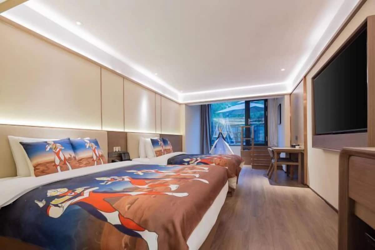 Een moderne hotelkamer met een groot bed, een bureau en een televisie.
