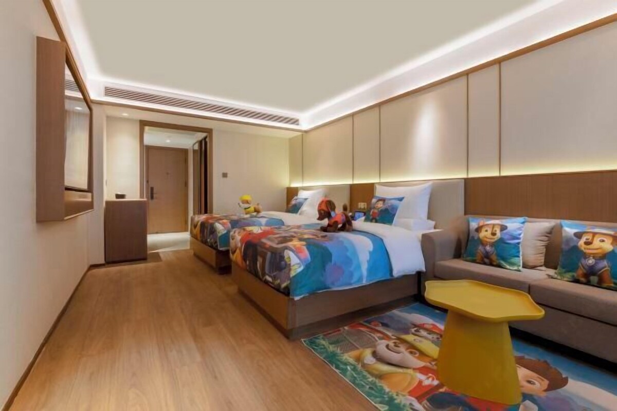 Une chambre d’hôtel avec un lit, un canapé, une petite table et un miroir.
