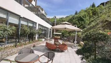 An outdoor patio with seating, a table, and a large umbrella.