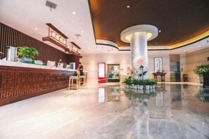 A hotel lobby with a reception desk, a central column, and a polished floor. - Wenbi Hotel (Changzhou)