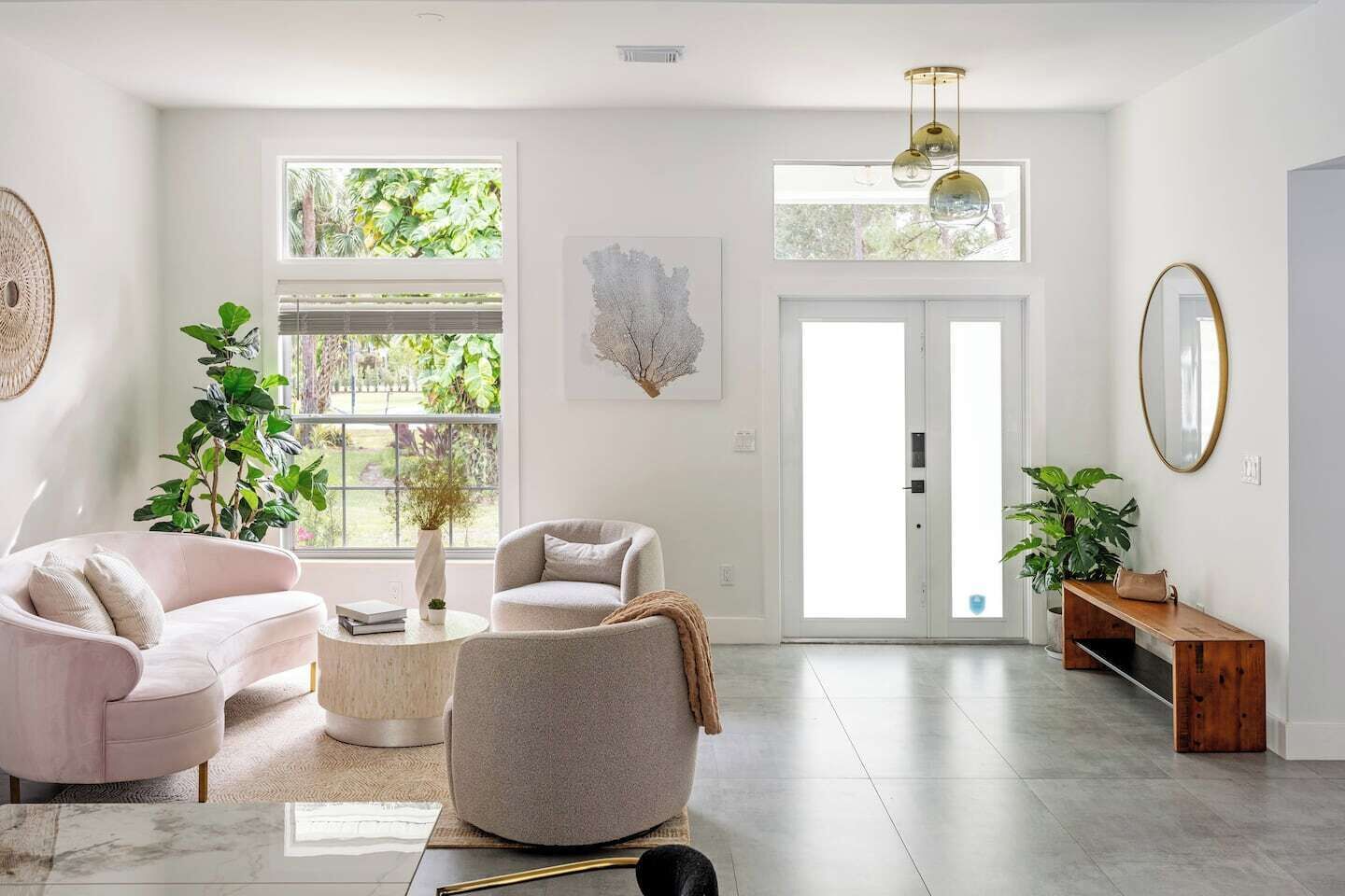 A spacious living room with a large window, two sofas, a coffee table, and a wooden bench.