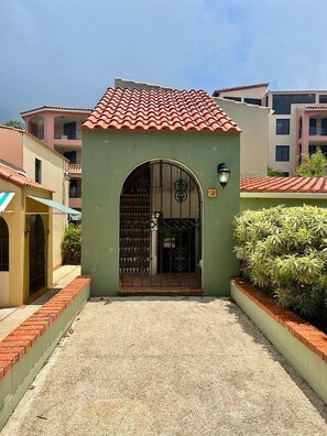 Un edificio con tetto in tegole, ingresso verde e cancello in metallo.