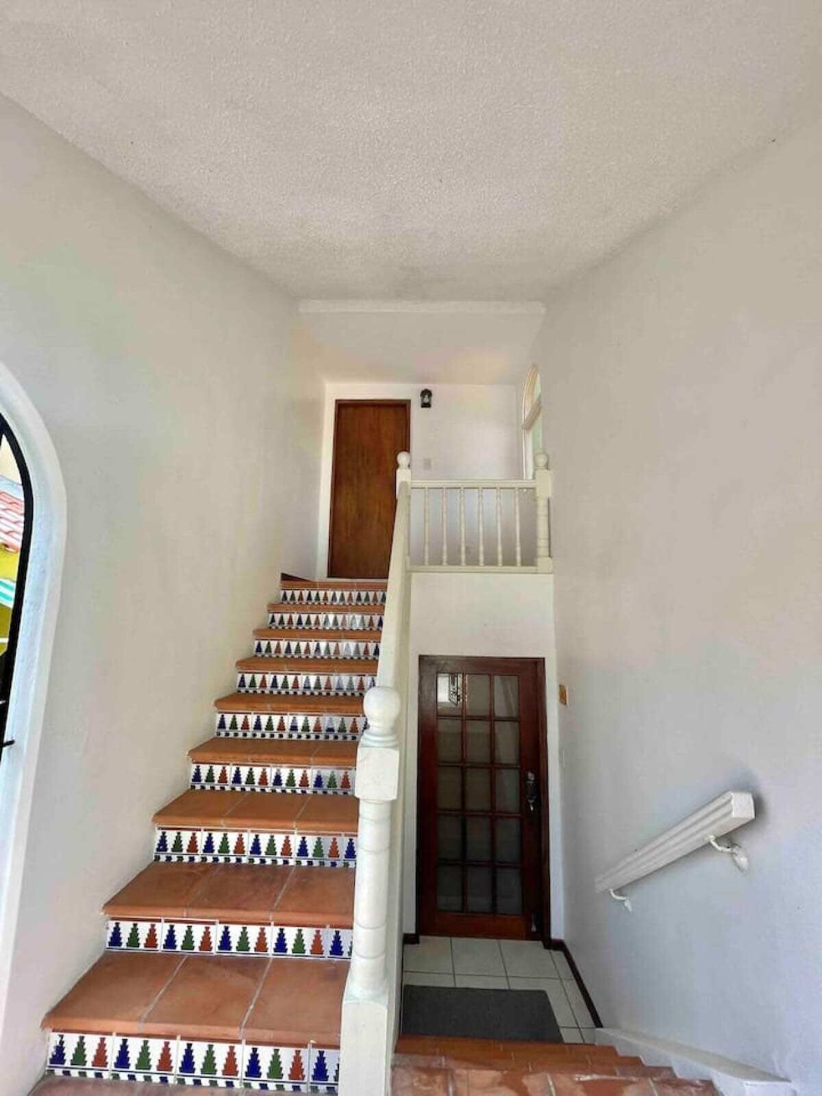 Un escalier orné de carreaux décoratifs menant à un deuxième étage.