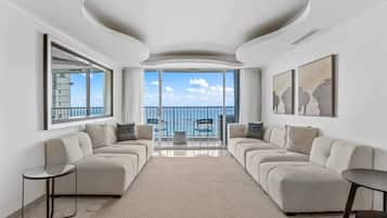 Un salon moderne avec un ensemble de canapés, une table basse et une vue sur le balcon.