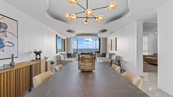 Une salle de conférence spacieuse, dotée d’une grande table, d’un lustre moderne et de sièges confortables.