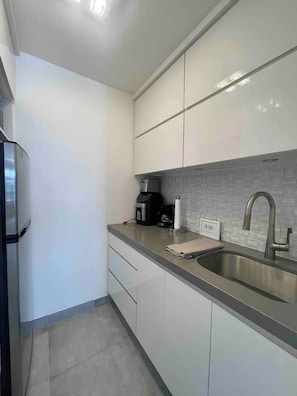 Fridge, microwave, coffee/tea maker, cookware/dishes/utensils