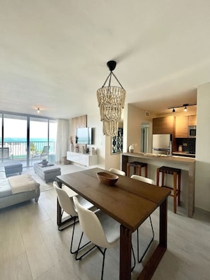 Un salon moderne comprenant un coin repas, une cuisine et un balcon avec vue.