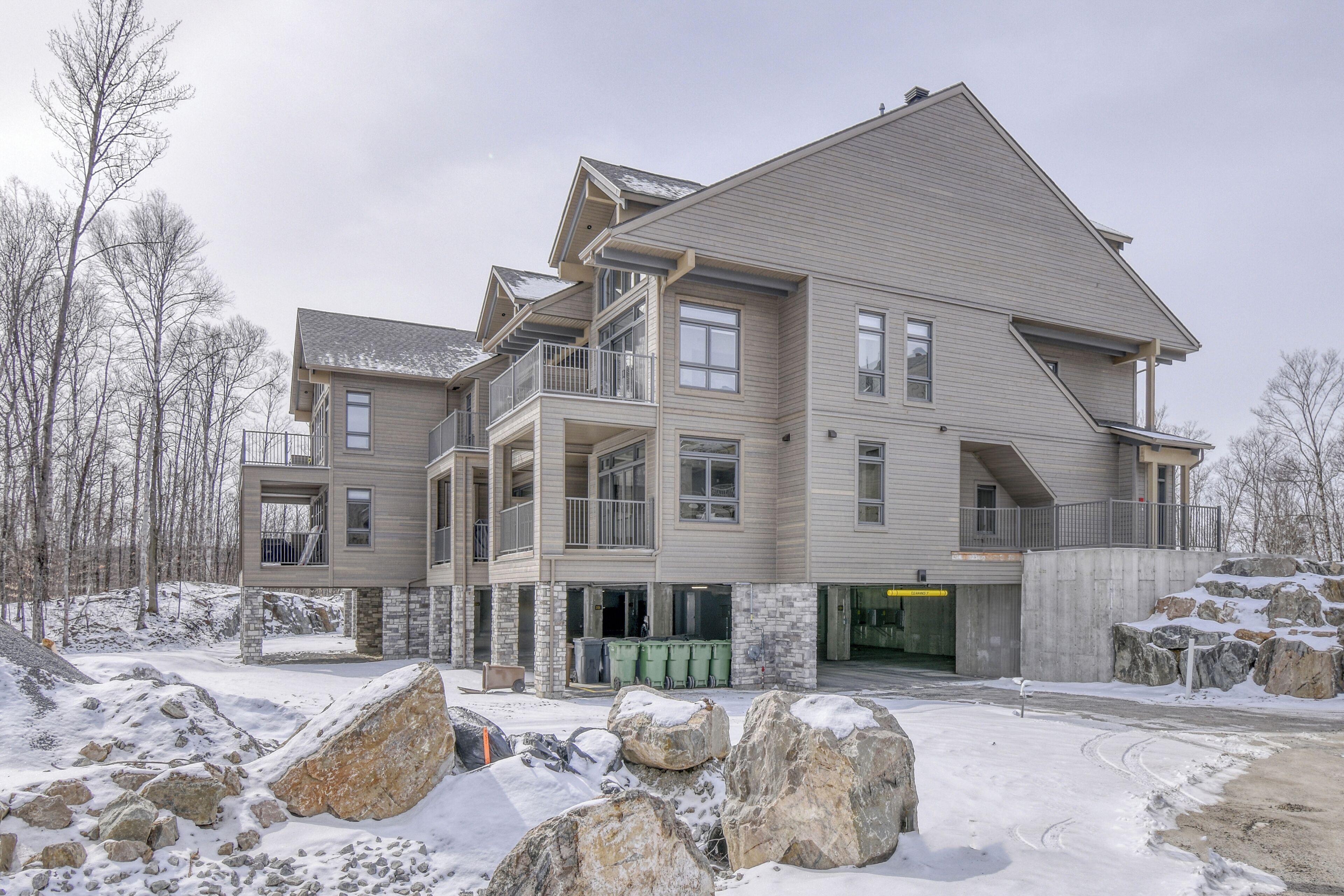 A multi-story building with balconies, a garage, and a stone facade.