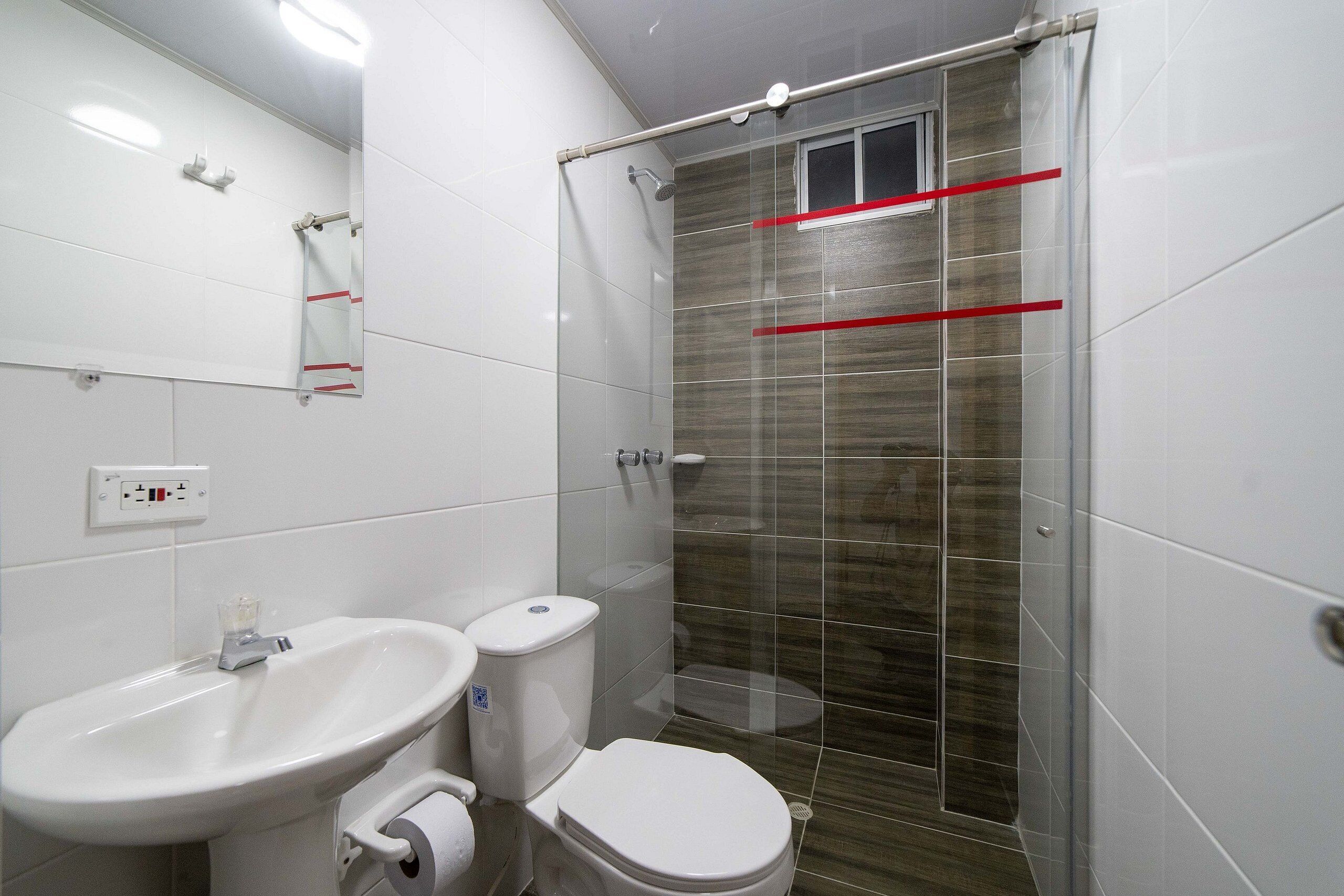 A bathroom with a sink, toilet, and shower area.