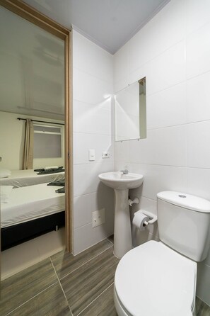 Habitación básica doble | Baño | Ducha, toallas, jabón y papel higiénico