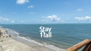 A beach with a wooden railing and the text "Stay Tall" on the water. - Beira Mar-Cozinheira-Piscina-4QT-SH029 (Sirinhaem)