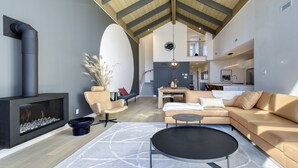 Amplia sala de estar con chimenea, un sofá, una mesa de centro y un comedor.
