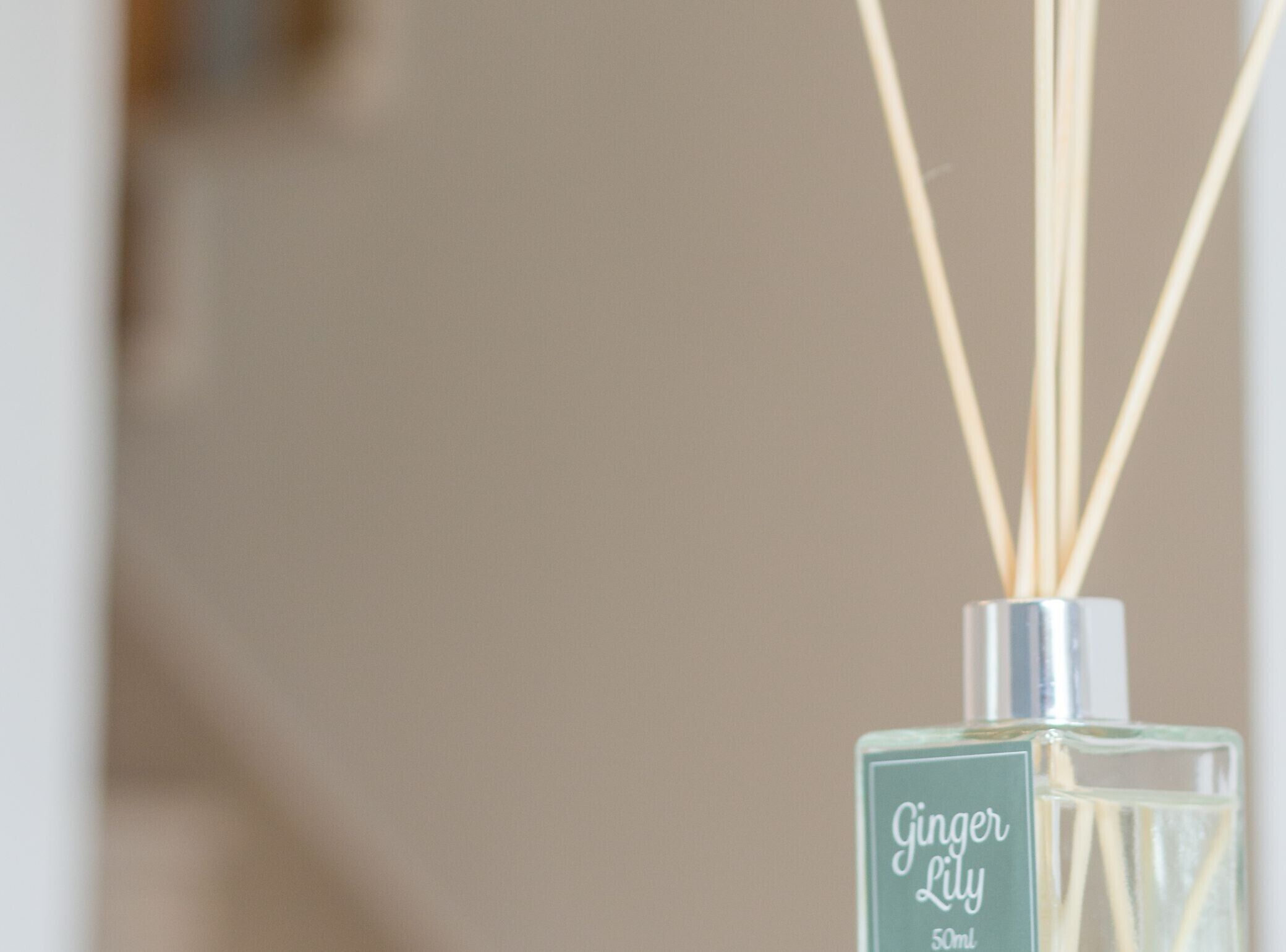 A bottle of Ginger Lily cologne with reed diffusers.