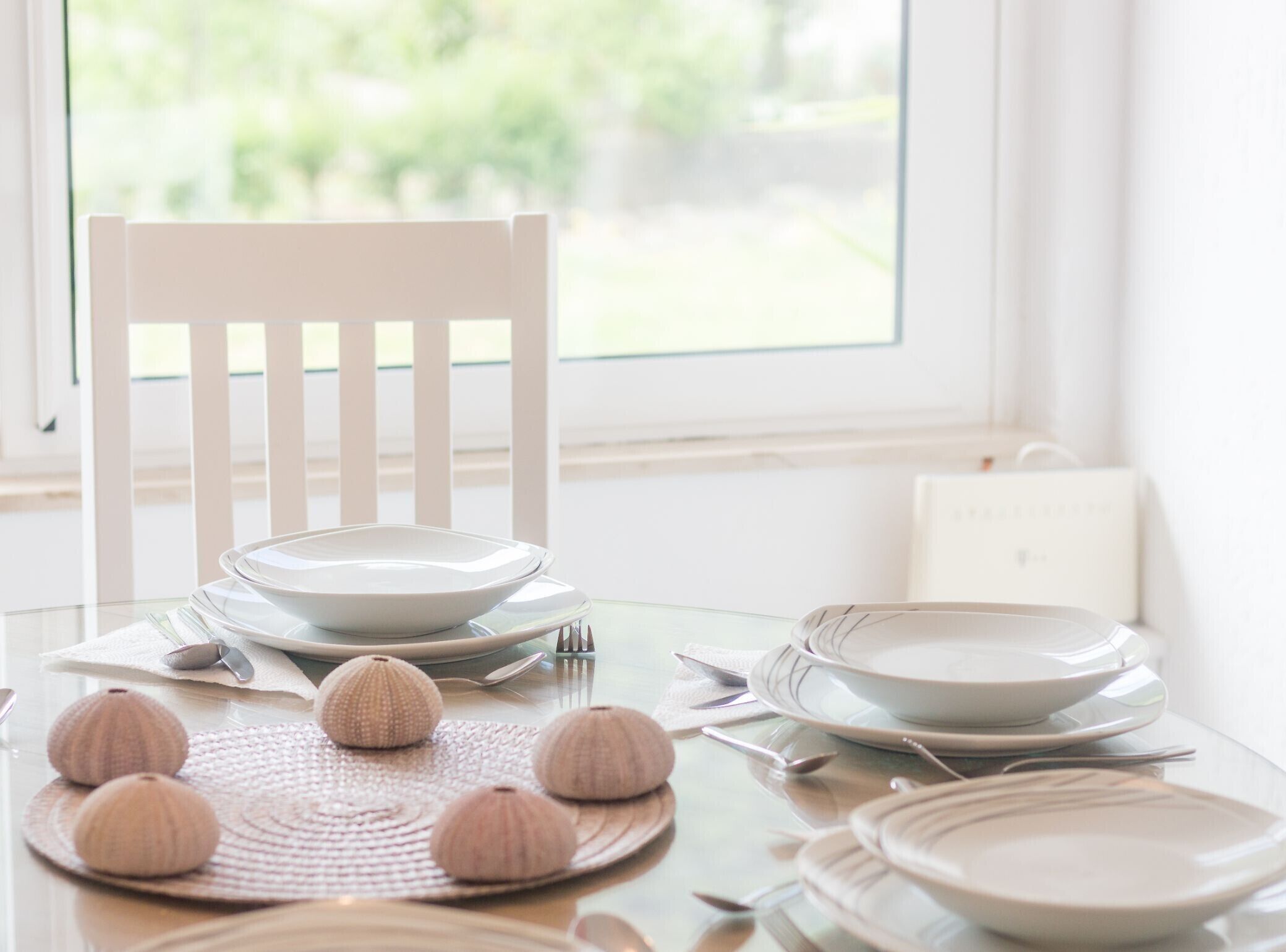 A dining table set with plates, cutlery, and decorative items.