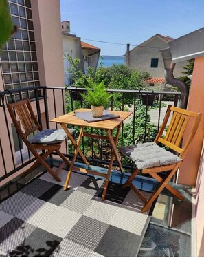 Enjoy a peaceful retreat on your balcony with a table, two chairs, and a potted plant.