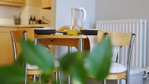 Eine Küche mit Holzausstattung, einem Esstisch mit Stühlen, einer Karaffe und einem Glas Orangensaft.