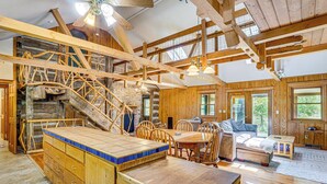 A spacious wooden cabin with a large dining area, a cozy living room, and a stone fireplace. - Historic Clark Cabin w/ Deck & Fishing Pond Access (Clark)
