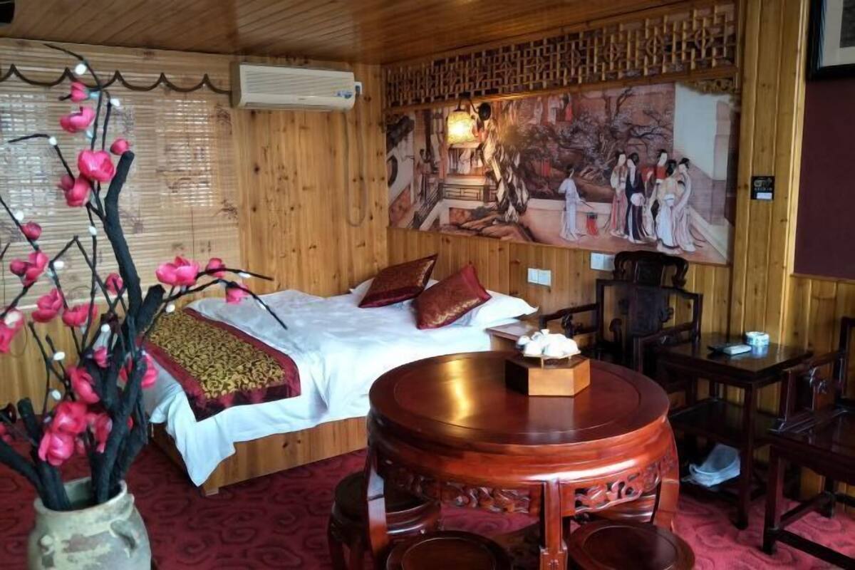 A traditional room with a bed, a wooden table, and a painting on the wall.