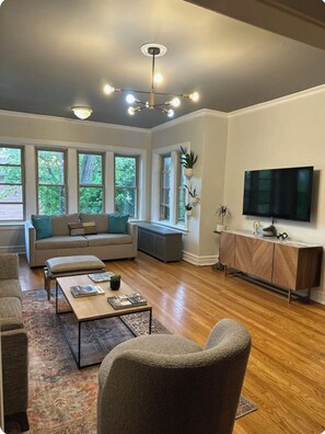 Un salon moderne avec un canapé, une table basse et un téléviseur.