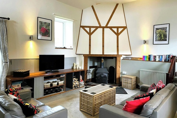 Sofas, rug on the floor, TV on a cabinet and stairs